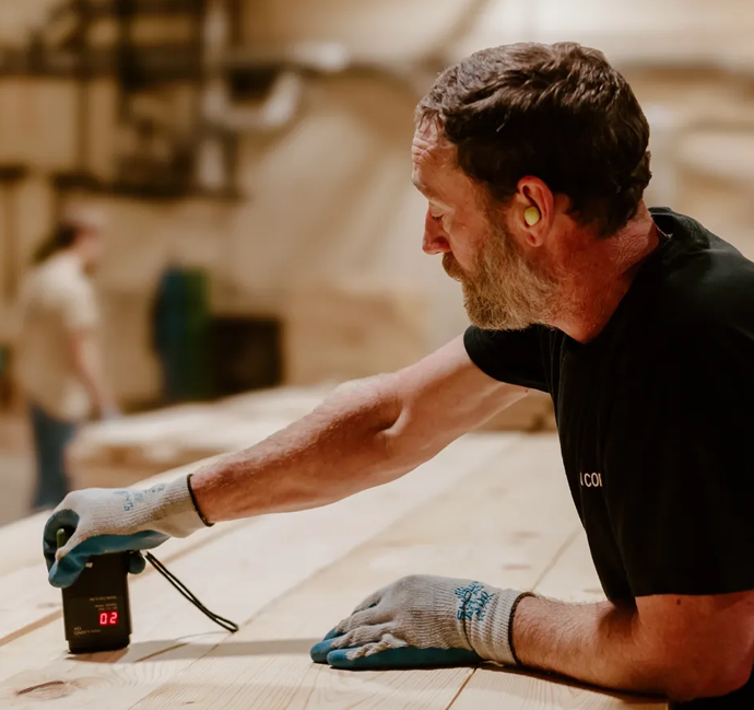 A man holding a drill and looking at something.