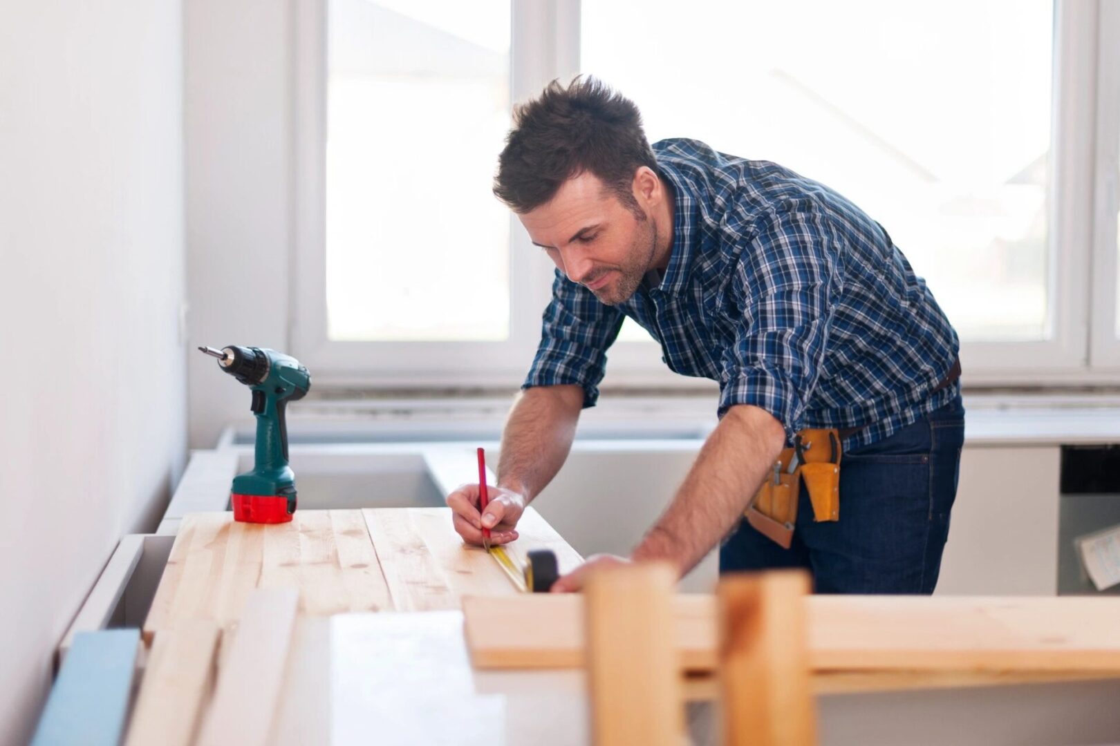 A man working on a table with a drill.